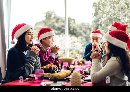 Portrait von Happy Big Family feiern santa Hüte zusammen Spaß haben und Mittagessen Ausgabe Zeit zusammen genießen in der Weihnachtszeit zu Hause Stockfoto