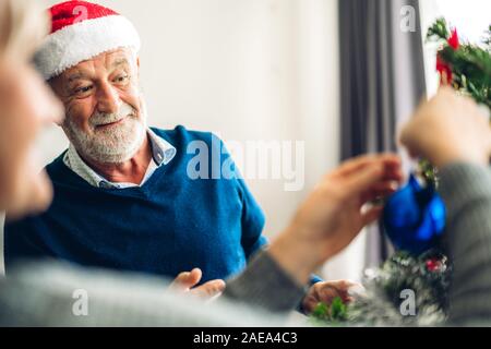 Romantische süße Senior paar entspannende schmücken Weihnachtsbaum und lächelnd, während Silvester feiern und genießen die Zeit zusammen in der Chr Stockfoto