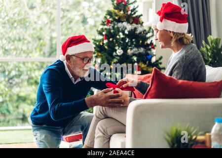 Romantische süße älteres Ehepaar in Santa Hüte Spaß und lächelnd, während Silvester feiern und genießen, Zeit miteinander zu verbringen. Ältere Mann, Stockfoto