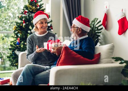 Romantische süße älteres Ehepaar in Santa Hüte Spaß und lächelnd, während Silvester feiern und genießen, Zeit miteinander zu verbringen. Ältere Mann, Stockfoto