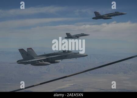 Us Marine Corps F/A-18C Hornet's fly neben einem US Air Force HC-130J Bekämpfung König II über die Mojave Wüste, Kalifornien, November 26, 2019. Die beiden Einheiten durchgeführt eine Luftbetankung Training Mission. (U.S. Air Force Foto: Staff Sgt. Betty R. Chevalier) Stockfoto