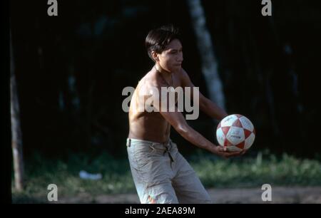 In einem kleinen, abgelegenen, indigenen Quechua (Quechua) Gemeinschaft im ecuadorianischen Amazonasgebiet, ein junger Mann spielt Volleyball. Stockfoto