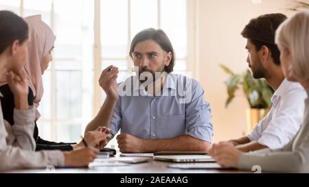 Schweren männlichen team leader Projekt Details erklären, konzentriert zu Kollegen. Stockfoto