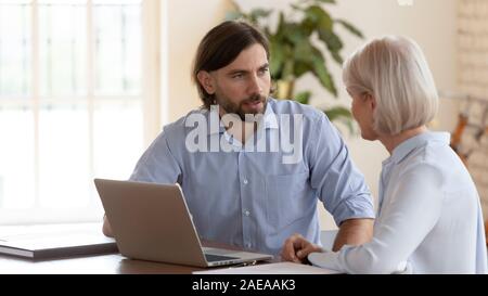 Kollegen diskutieren Projekt Einzelverkäufe, zusammen am Arbeitsplatz sitzen. Stockfoto