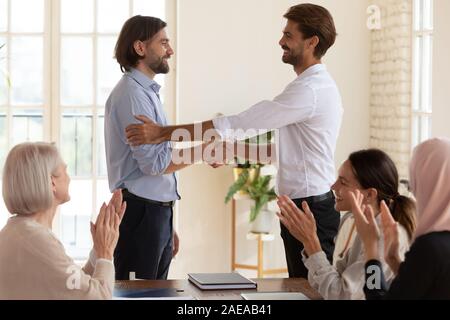 Lächelnd boss Händeschütteln mit glücklichen männlichen Kollegen. Stockfoto