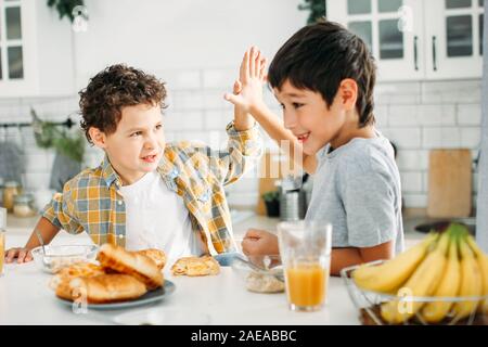 Zwei Geschwister tween jungen Brüder beim Frühstück auf helle Küche zu Hause. Stockfoto