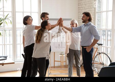 Mittleren Alters und Jungen multirassischen Kollegen hoch fünf überglücklich. Stockfoto