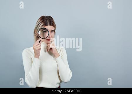 Junge Frau in der Mode Shirt an Lupe suchen, Ernst Stockfoto