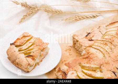 Ansicht von oben auf dem Teller mit hausgemachten crispy Apple Pie mit weißem Textil- und Golden Ears von Roggen. Home Backen. Gesunde Ernährung Konzept Stockfoto