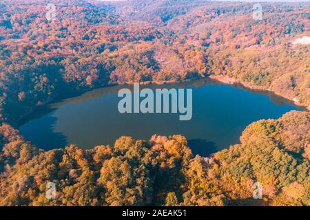 Schönen Bergsee im Herbst. Luftaufnahme. Natur Landschaft. Blick auf den bunten Herbst Wald rund um den See Stockfoto