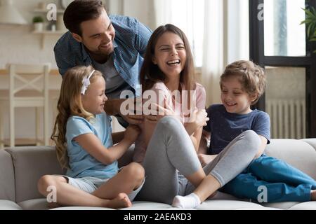 Mann mit kleinen Kindern kitzeln lachende Frau Stockfoto