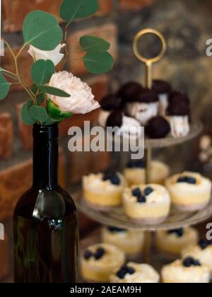 Ein großer stand der Muffins hinter eine Rose in eine Flasche Wein Stockfoto