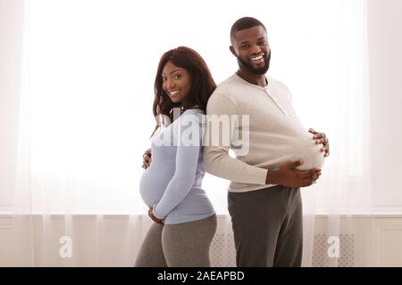 Schwangere paar Vergleich der Größe Ihrer großen Bauch Stockfoto