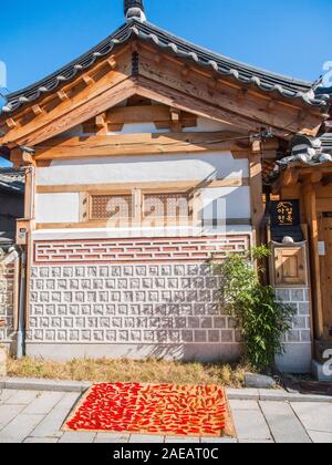 Rote Chilis, die in der Sonne zu trocknen, auf Zuckerrohr Matte, auf der Straße, außerhalb der traditionellen hanok Haus, Tongin Markt, Seoul, Südkorea Stockfoto