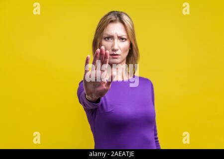 Nein, verboten! Portrait von umgekippt junge Frau in engen lila Kleid zeigt stop Geste, ein Verbot oder eine Warnung Ausdruck mit runzelte besorgt. Stockfoto