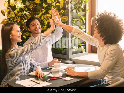 Partner einander hoch fünf während Business Lunch geben Stockfoto