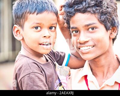 PUDUCHERRY, Indien - Dezember Circa, 2018. Nicht identifizierte nett lächelnden Teenager mit Bruder in die Arme zusammen draußen auf der Straße des Dorfes o Stockfoto