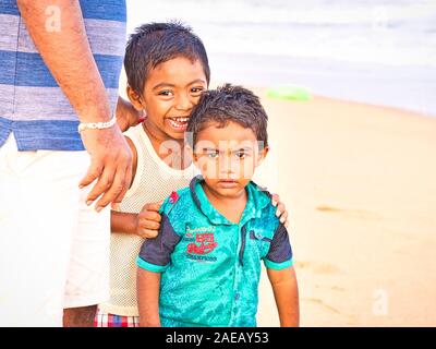 PUDUCHERRY, Indien - Dezember Circa, 2018. Nicht identifizierte schüchtern peinlich Sohn stehend sein Vati in die Straße, in der sich ein Dalit Dorf in der Nähe Stockfoto