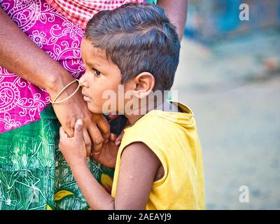 PUDUCHERRY, Indien - Dezember Circa, 2018. Nicht identifizierte schüchtern peinlich Sohn stand seine Mutter in die Straße, in der sich ein Dalit Dorf in der Nähe Stockfoto