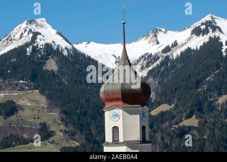 Top der Österreichischen Kirche vor der schneebedeckten Berge in den Alpen Stockfoto