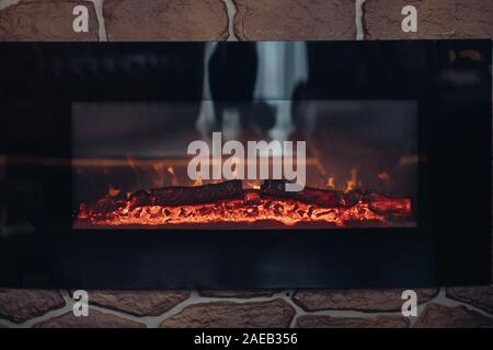 Kamin mit brennenden Holzscheite. In der Nähe von steinernen Kamin mit brennenden oder Glimmenden Protokolle in Brand. Stockfoto