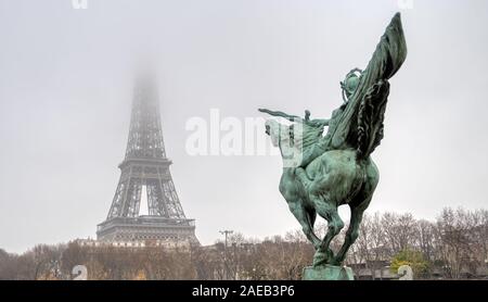 Eiffelturm und Bir Hakeim - Statue auf einem nebligen Tag Stockfoto