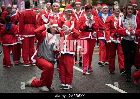 Über sieben tausend Mitglieder der Öffentlichkeit in Glasgow's jährliche Weihnachten Santa Strich durch die Innenstadt. Die Santa Dash hat seit 2006 und im Laufe der Jahre hat Hunderte von Tausende von Pfund für Nächstenliebe in und um Glasgow zu arbeiten. Stockfoto