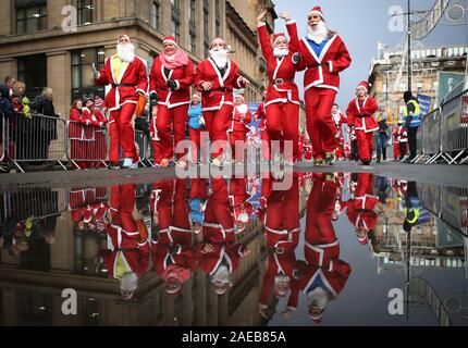 Über sieben tausend Mitglieder der Öffentlichkeit in Glasgow's jährliche Weihnachten Santa Strich durch die Innenstadt. Die Santa Dash hat seit 2006 und im Laufe der Jahre hat Hunderte von Tausende von Pfund für Nächstenliebe in und um Glasgow zu arbeiten. Stockfoto