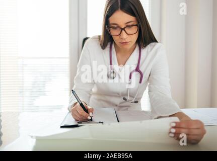 Junge Ärztin im Büro Schreibtisch Stockfoto