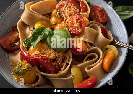 Gesundes Vollkornbrot Pappardelle mit frischen Tomaten und Basilikum, und einer veganen Mutter basiert. Stockfoto