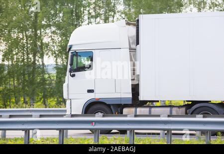 Big White Truck geht auf der Autobahn in der Nähe von Stockfoto