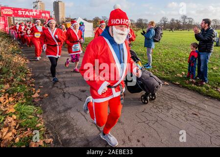 London, Großbritannien. 08 Dez, 2019. Der Start - London Santa Dash 2019 - Tausende von verkleidet als Weihnachtsmann auf eine optionale 5k- oder 10k London Santa Dash Kurs in Brockwell Park zu helfen, Kapital für schwer kranke Kinder aus ganz Großbritannien heben, die betreut werden, für die in der Great Ormond Street Hospital (GOSH). Credit: Guy Bell/Alamy leben Nachrichten Stockfoto