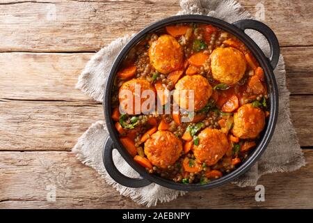 Würzige Frikadellen mit Linsen garnieren in Tomatensoße close-up in einer Pfanne auf dem Tisch. Horizontal oben Ansicht von oben Stockfoto