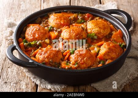 Würzige Frikadellen mit Linsen garnieren in Tomatensoße close-up in einer Pfanne auf dem Tisch. Horizontale Stockfoto