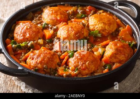 Marokkanische Frikadellen serviert mit Linsen in Tomatensoße close-up in einer Pfanne auf dem Tisch. Horizontale Stockfoto