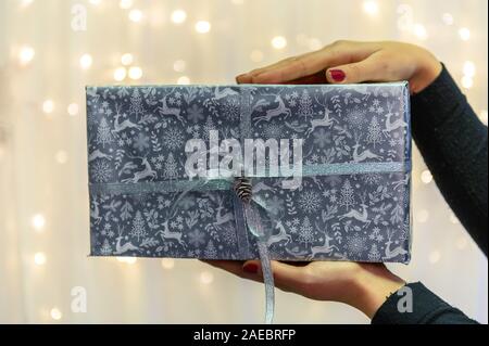 Weihnachtsgeschenk. Herzlichen Glückwunsch. nach oben Blick von Frau mit traditionellen gestalteten Geschenkbox. Stockfoto