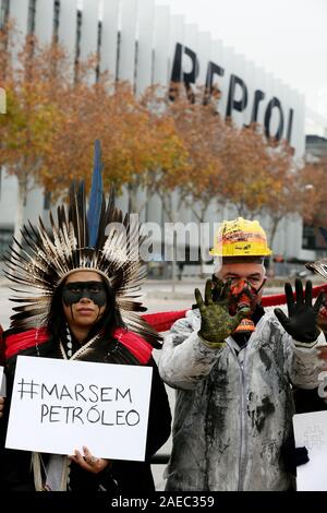 Madrid, Spanien. 08 Dez, 2019. 350.Org indigenen Führern und Aktivisten protestieren in Madrid gegen Ölverschmutzung, der fossilen Industrie in Brasilien im Rahmen der COP 25. Aufmerksamkeit auf das Auslaufen von Öl, Verschmutzung der Strände und verschmutzen das Sea Life in 11 Staaten in Brasilien in den letzten drei Monaten zu zeichnen, indigene Vertreter aus fünf verschiedenen Völkern und Aktivisten von 350.Org wird ein Protest in einem der berühmtesten Plätze von Madrid, die Smart Building von Repsol die Spanische Ölgesellschaft. Quelle: dpa Picture alliance/Alamy leben Nachrichten Stockfoto