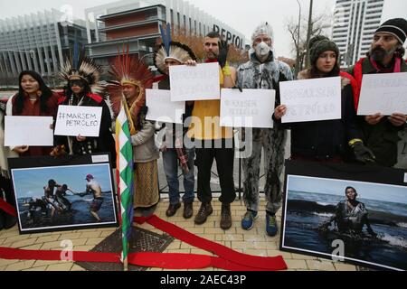 Madrid, Spanien. 08 Dez, 2019. 350.Org indigenen Führern und Aktivisten protestieren in Madrid gegen Ölverschmutzung, der fossilen Industrie in Brasilien im Rahmen der COP 25. Aufmerksamkeit auf das Auslaufen von Öl, Verschmutzung der Strände und verschmutzen das Sea Life in 11 Staaten in Brasilien in den letzten drei Monaten zu zeichnen, indigene Vertreter aus fünf verschiedenen Völkern und Aktivisten von 350.Org wird ein Protest in einem der berühmtesten Plätze von Madrid, die Smart Building von Repsol die Spanische Ölgesellschaft. Quelle: dpa Picture alliance/Alamy leben Nachrichten Stockfoto