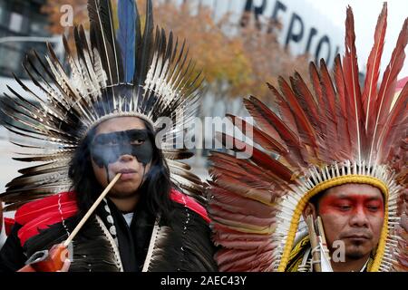 Madrid, Spanien. 08 Dez, 2019. 350.Org indigenen Führern und Aktivisten protestieren in Madrid gegen Ölverschmutzung, der fossilen Industrie in Brasilien im Rahmen der COP 25. Aufmerksamkeit auf das Auslaufen von Öl, Verschmutzung der Strände und verschmutzen das Sea Life in 11 Staaten in Brasilien in den letzten drei Monaten zu zeichnen, indigene Vertreter aus fünf verschiedenen Völkern und Aktivisten von 350.Org wird ein Protest in einem der berühmtesten Plätze von Madrid, die Smart Building von Repsol die Spanische Ölgesellschaft. Quelle: dpa Picture alliance/Alamy leben Nachrichten Stockfoto