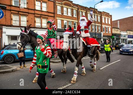 Wimbledon, UK. 08 Dez, 2019. Santa Claus kommt früh auf dem Pferderücken für Weihnachten in Wimbledon Village an der High Street Village Weihnachtsmarkt, im Südwesten von London, Vereinigtes Königreich. 08 Deecember 2019, London, England, Vereinigtes Königreich Quelle: Jeff Gilbert/Alamy leben Nachrichten Stockfoto