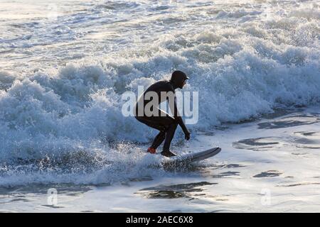 Bournemouth, Dorset UK. 8. Dezember 2019. UK Wetter: Wind und Wellen Zunahme der Größe als Sturm Atiyah Ansätze in Bournemouth Strand als Surfer das Beste aus den Bedingungen zu machen. Credit: Carolyn Jenkins/Alamy leben Nachrichten Stockfoto