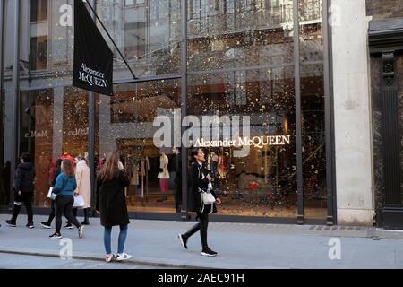 Menschen zu Fuß hinter Alexander McQueen store Exterieur Weihnachten auf Old Bond Street in Mayfair, London W1 England UK KATHY DEWITT Stockfoto