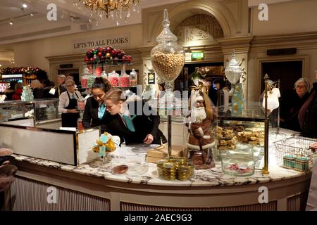 Fortnum & Mason Süßigkeiten und Schokolade counter store Arbeitnehmer im Innenraum an Weihnachten in Piccadilly London England UK KATHY DEWITT Stockfoto