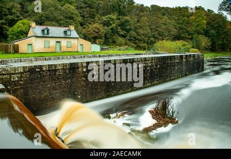 Lange Belichtung auf den Lock auf einen Kanal. Die schlammigen Wasser sprudelt aus der Verdammung des zweiten Verschluss von Coat Natous auf dem Kanal von Nantes nach Brest. Stockfoto