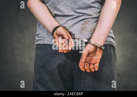 Verhaftet Mann in Handschellen mit Handschellen die Hände hinter dem Rücken. Stockfoto