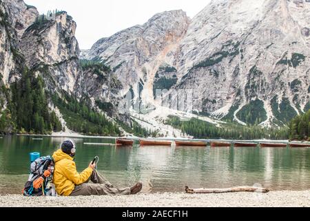 Jungen Touristen Wanderer Mann Musik von alpinen See Lago di Braies (Pragser Wildsee) im Trentino, Dolomiten, Italien. Stockfoto