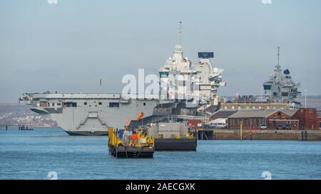 Die Royal Navy Flugzeugträger HMS Prince of Wales (R09) wird offiziell in Betrieb mit der Inbetriebnahme Zeremonie an der Portsmouth Naval Base, Großbritannien am 10. Dezember 2019 angenommen werden. Die Zeremonie wird von seiner Königlichen Hoheit des Prinzen von Wales und seine königliche Hoheit, der Herzogin von Cornwall als Sponsor des Schiffes besucht werden. Das Schiff ist hier am 4. Dezember 2019 Neben der Naval Base mit HMS Queen Elizabeth im Hintergrund zu sehen. Stockfoto