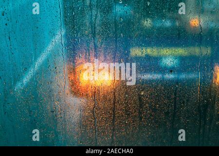 Tropfen Regen auf Glas auf Glas Hintergrund. Abstrakte Straße bunter Hintergrund. Stockfoto