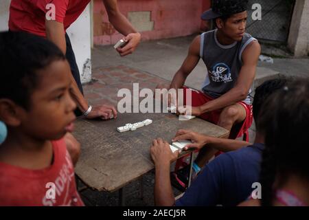 Caracas, Miranda, Venezuela. 30 Nov, 2019. Junge Männer spielen ein Spiel der Dominos. Eine große Krise geschieht in dem südamerikanischen Land von Venezuela. Eine korrupte Regierung und massive Inflation führte zu einer großen Krise throghout des Landes. Die in armen Slums sind stark leiden. Der Slum von Petare ist einer der Bereiche, die am meisten leiden. Credit: Allison Abendessen/ZUMA Draht/Alamy leben Nachrichten Stockfoto