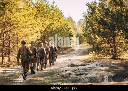 Gruppe der Re-enactors gekleidet, wie Sowjetische Russische Rote Armee Infanterie Soldaten des Zweiten Weltkriegs Marschieren entlang der Forststraße im Sommer Herbst Saison. Stockfoto